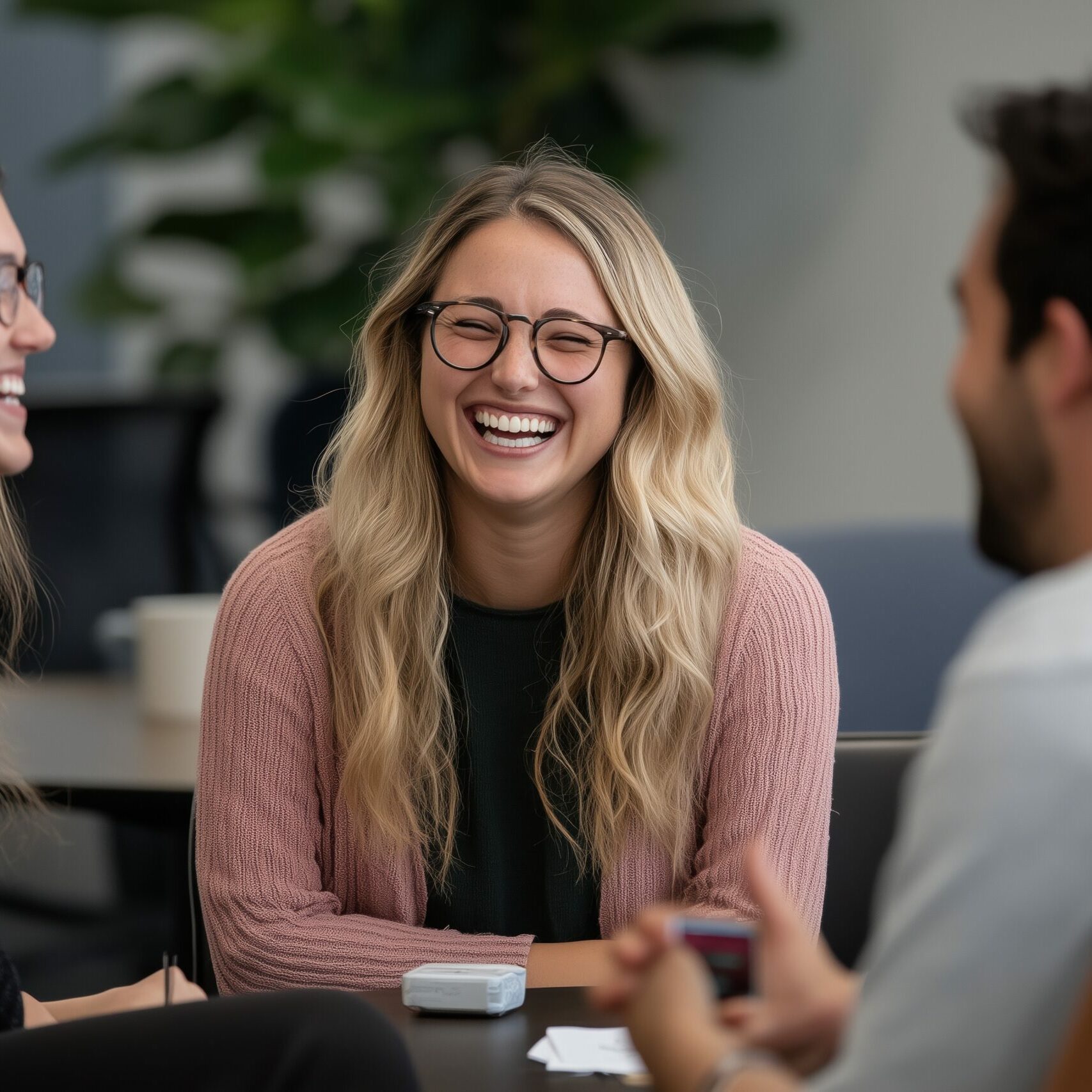 Laughing Team: A group of three colleagues engages in a lively conversation, their faces lit up with genuine smiles, and the camaraderie is palpable.
